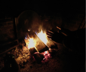 Hands warming over a fire.